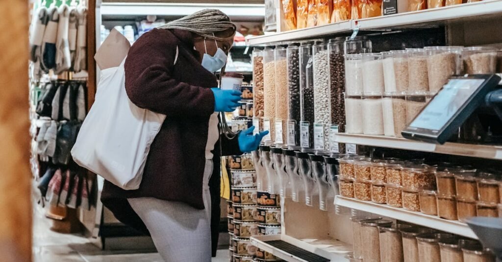 Plus size woman wearing mask and gloves selecting grains in a supermarket aisle.